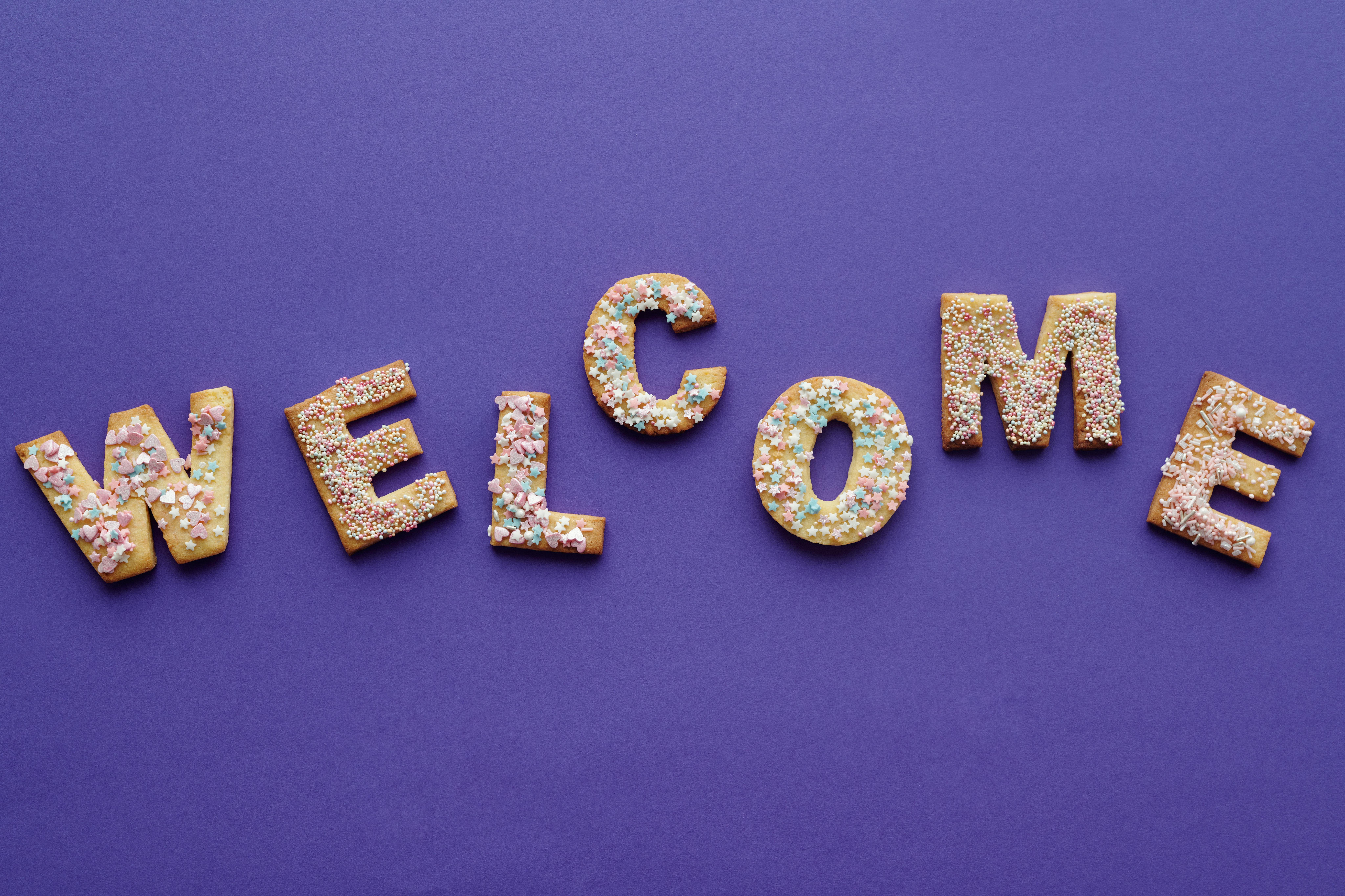 Welcome image, depicted in biscuits with a purple background.
