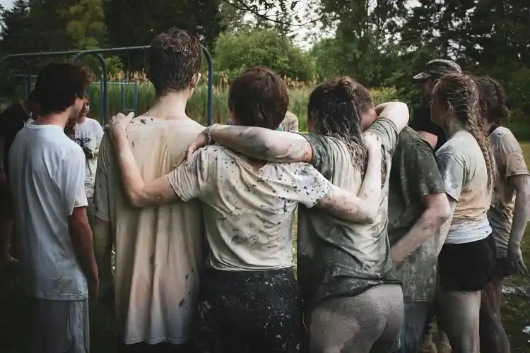 A group of teenagers stand together, after some sort of physical education